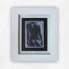 Oil painting of a female nude from behind in deep blue-black and grey against a dark ground, by Julie Tugwell.